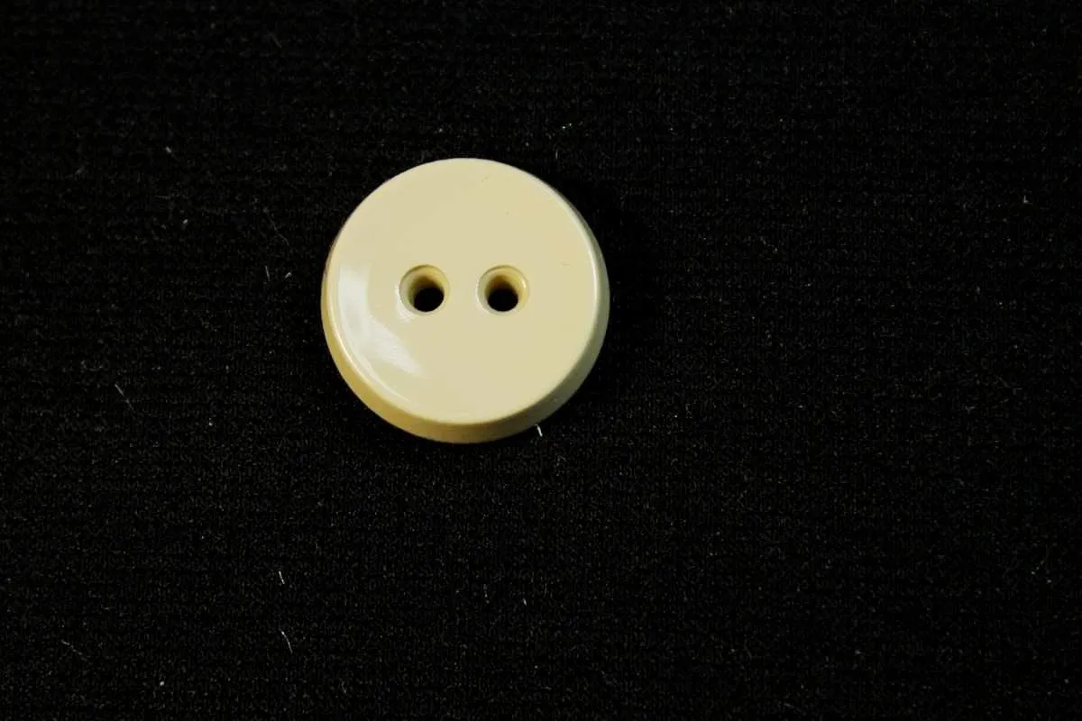 Пуговица пластмассовая, два прокола, бежевого цвета, глянцевая, диаметр 17 ммизображение
