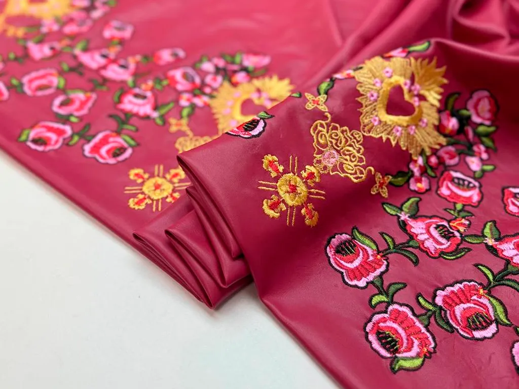 Экокожа с цветочной вышивкой по одному краю, фон красныйизображение